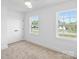 Bright bedroom with neutral carpet, white walls, two windows and a closet at 7205 Church Rd, Taylorsville, NC 28681