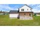 New construction home showing modern farmhouse design with stone foundation and manicured lawn at 7205 Church Rd, Taylorsville, NC 28681