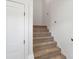 Carpeted staircase leading upstairs with white walls and a white door at 7205 Church Rd, Taylorsville, NC 28681