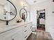 Bright primary bathroom with double sinks, quartz countertop, tiled floors, walk-in shower, and closet at 7324 Swans Run Rd, Charlotte, NC 28226