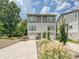 Modern two-story townhome with a concrete driveway, lush landscaping, and attached one-car garage at 7324 Swans Run Rd, Charlotte, NC 28226