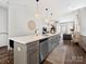 Modern kitchen island with seating, seamless flow to the living space, and stylish pendant lights at 7324 Swans Run Rd, Charlotte, NC 28226