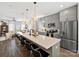 Modern kitchen island with bar seating, pendant lights, and seamless flow to the living area at 7324 Swans Run Rd, Charlotte, NC 28226