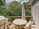 Outdoor patio with covered grill and table with umbrella nestled in a wooded setting at 7324 Swans Run Rd, Charlotte, NC 28226