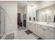 Bright bathroom with double vanity, shower with glass door, and access to a walk-in closet at 7518 Porrera St, Charlotte, NC 28214