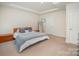 Bedroom featuring neutral carpet, a tray ceiling, and ample natural light from the adjacent windows at 7518 Porrera St, Charlotte, NC 28214