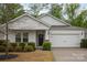 Charming home featuring a two-car garage, stone accents and well-manicured landscaping enhancing its curb appeal at 7518 Porrera St, Charlotte, NC 28214
