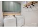 Convenient laundry room features a washer, dryer, storage cabinets, and a hanging rack at 7518 Porrera St, Charlotte, NC 28214