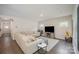 Inviting living room featuring hardwood floors, a large sectional, and a modern entertainment center at 7518 Porrera St, Charlotte, NC 28214
