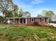 Charming brick home with a well-maintained lawn, mature trees, and traditional architectural details at 827 Ford Dr, Lowell, NC 28098