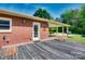View of the backyard from a deck with a brick home and covered patio at 904 Sunbeam Dr, Lincolnton, NC 28092