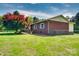 A side view of the property features a classic brick exterior with green shutters and a manicured lawn at 904 Sunbeam Dr, Lincolnton, NC 28092