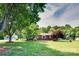 Charming brick ranch home with a well-maintained lawn, mature trees, and a detached garage on a sunny day at 904 Sunbeam Dr, Lincolnton, NC 28092