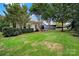 Lush backyard showcasing a stone patio, a grill, outdoor seating, green grass, and a fence at 908 Gardenia St, Fort Mill, SC 29708