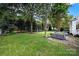 Spacious backyard with a stone patio, comfortable seating, a grill, mature trees, and well-maintained lawn at 908 Gardenia St, Fort Mill, SC 29708
