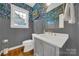Charming powder room featuring floral wallpaper, grey wainscoting, and hardwood floors at 908 Gardenia St, Fort Mill, SC 29708