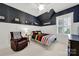 Charming bedroom featuring board and batten, dark accent wall and a colorful striped comforter at 908 Gardenia St, Fort Mill, SC 29708