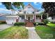 Charming two-story white home with a brick porch, manicured lawn and meticulous landscaping at 908 Gardenia St, Fort Mill, SC 29708