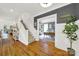 Hallway featuring hardwood floors, stairs, and a view into the sunlit home office at 908 Gardenia St, Fort Mill, SC 29708