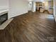 Spacious living room featuring dark hardwood floors, fireplace, and open layout to the kitchen area at 9527 Scotland Hall Ct, Charlotte, NC 28277