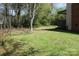 Lush, green backyard with trees and partial view of deck with a pergola at 9915 Lottie Ln, Charlotte, NC 28262