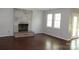 Cozy living room showcasing a brick fireplace, natural light, and hardwood floors at 9915 Lottie Ln, Charlotte, NC 28262