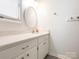 Bright bathroom featuring a white vanity with a marble countertop and an oval mirror at 1022 Kenilworth Nw Ct, Concord, NC 28027