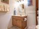 Classic bathroom with a wood vanity and a large mirror, complemented by wainscoting at 1022 Kenilworth Nw Ct, Concord, NC 28027