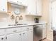 Functional kitchen with white cabinets, stainless steel dishwasher, and neutral countertops at 1022 Kenilworth Nw Ct, Concord, NC 28027