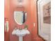 Stylish half bathroom with a pedestal sink, decorative mirror, and attractive wall color at 107 Iris Meadow Dr, Mooresville, NC 28115