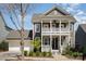 Charming two-story home featuring a double porch, well-manicured landscaping, and a two-car garage at 107 Iris Meadow Dr, Mooresville, NC 28115