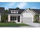Charming home showcasing a mix of stone and siding, complemented by a manicured lawn and inviting curb appeal at 1131 Meander Ln, Waxhaw, NC 28173