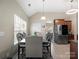 Bright dining room with a modern table and chairs set beneath an elegant chandelier at 13510 Brandon Trail Dr, Charlotte, NC 28213