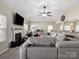 Relaxing living room featuring a fireplace, a large TV, and a corner office space with modern decor at 13510 Brandon Trail Dr, Charlotte, NC 28213