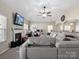 Stylish living room with a fireplace, a ceiling fan, and an adjacent office area with ample natural light at 13510 Brandon Trail Dr, Charlotte, NC 28213
