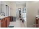 Bright bathroom with a vanity, walk-in closet, soaking tub, and neutral tile flooring at 13510 Brandon Trail Dr, Charlotte, NC 28213