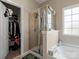 Bathroom shower with glass door and adjacent walk-in closet filled with clothes and shoes at 13510 Brandon Trail Dr, Charlotte, NC 28213