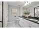 This bathroom offers marble floors, double sinks, white cabinets, matte black fixtures, and framed artwork at 13709 Roderick Dr # 193, Huntersville, NC 28078