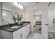 This bathroom has double sinks, white cabinets, black fixtures, marble tile floors, and a glass enclosed shower at 13709 Roderick Dr # 193, Huntersville, NC 28078