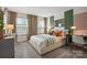 This cozy bedroom has a bed near windows, a dresser, neutral carpeting and walls, and a green accent stripe at 13709 Roderick Dr # 193, Huntersville, NC 28078
