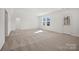 Large bonus room with neutral walls and carpet, bright windows, and an exterior door to the backyard at 13709 Roderick Dr # 193, Huntersville, NC 28078