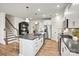 Open kitchen with island, stainless steel appliances, white cabinets, and hardwood floors at 13709 Roderick Dr # 193, Huntersville, NC 28078