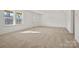 Sun-filled living room with new carpet, a door to the backyard, and large windows with wooded views at 13709 Roderick Dr # 193, Huntersville, NC 28078