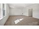 A modern living room with new carpet, a large window letting in light, and a doorway to other rooms at 13709 Roderick Dr # 193, Huntersville, NC 28078