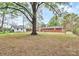 Expansive grassy backyard featuring mature trees and an exterior view of the red brick home at 140 Mickle Ct, Rock Hill, SC 29732