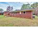 Exterior view of the red brick home featuring a small deck and a grassy backyard at 140 Mickle Ct, Rock Hill, SC 29732