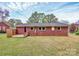 Back view of a brick home featuring a small wooden deck and a spacious backyard with a lush green lawn at 140 Mickle Ct, Rock Hill, SC 29732