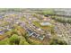 Aerial view displaying a neighborhood layout with houses, streets, pond, and green spaces at 15230 Ravenall Dr, Huntersville, NC 28078