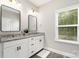 Bright bathroom featuring a dual sink vanity with stone countertops and sleek fixtures at 15230 Ravenall Dr, Huntersville, NC 28078