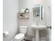 Charming powder room with a pedestal sink, decorative mirror, and stylish shelving at 15230 Ravenall Dr, Huntersville, NC 28078